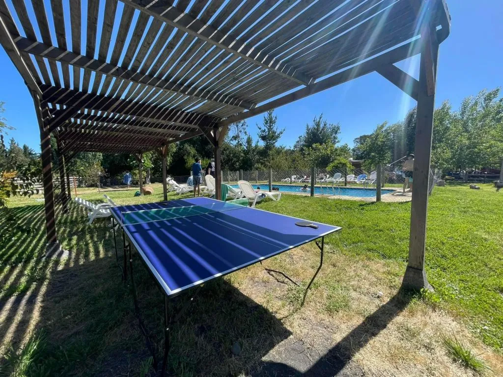 Tinaja de madera con pérgola y vista al río de aguas verdes en Camping Aguas Verdes